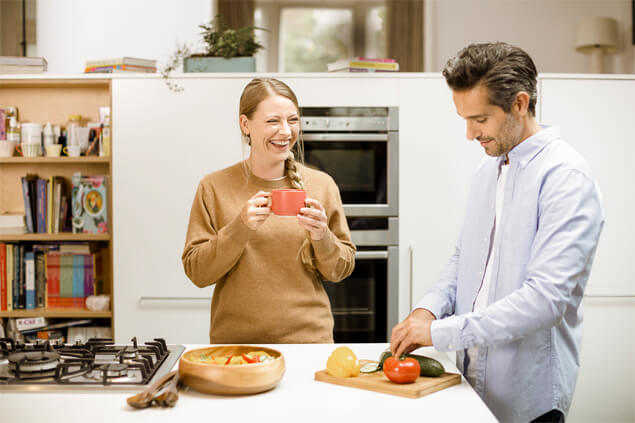 Pareja picando verduras en la cocina