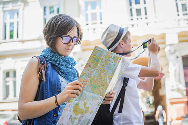 Chica en la calle mirando un mapa