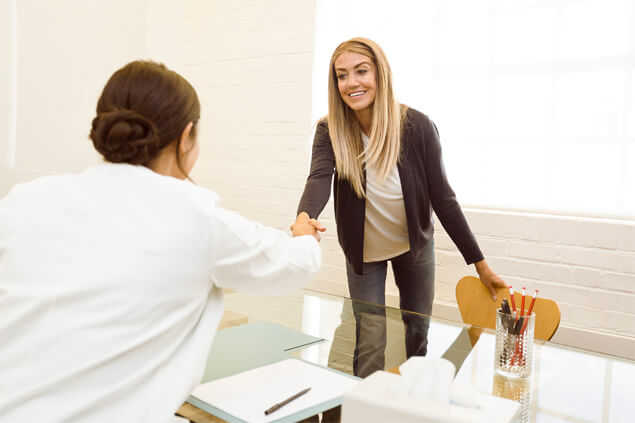 Señora y especialista saludándose en cita médica
