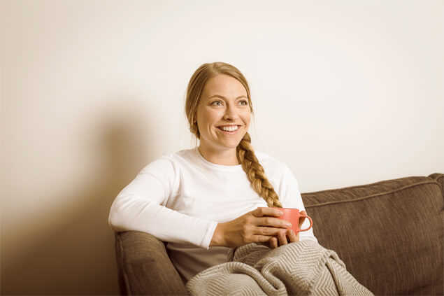 Chica riendo sentada en el sofa