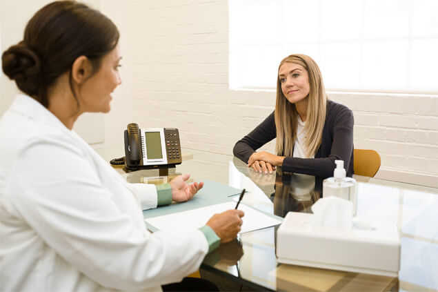 Mujer escuchando a especialista en cita médica