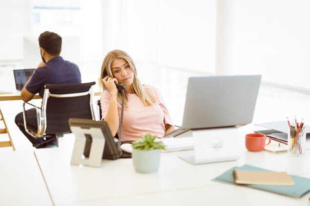 Mujer atendiendo el teléfono en su oficina