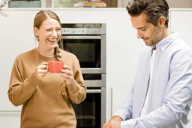 Pareja conversando alegremente en la cocina