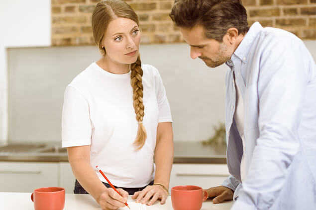 Pareja conversando y tomando apuntes