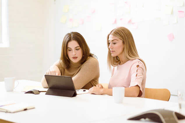 Dos mujeres mirando atentamente una tablet