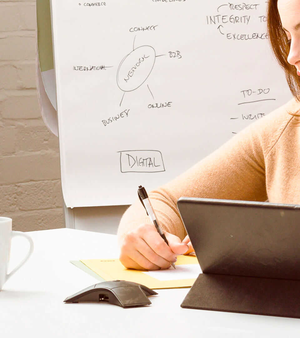 Chica tomando apuntes de un ordenador